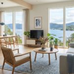 Offener Wohnraum in Cool Blue mit hellem Holz und Blick auf den Fjord