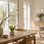 Heller Wohnraum im Frühling mit blühenden Kirschzweigen und Tulpen in Vasen