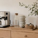 Kaffeestation auf einem Holzsideboard mit Maschine, Tassen und Korb