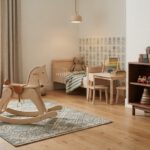 Nostalgisches Kinderzimmer: Holzspielzeug, ruhige Farben und weniger Plastik Kinderzimmer mit Schaukelpferd aus Holz, Holzspielzeug im Regal und gedeckten Farben