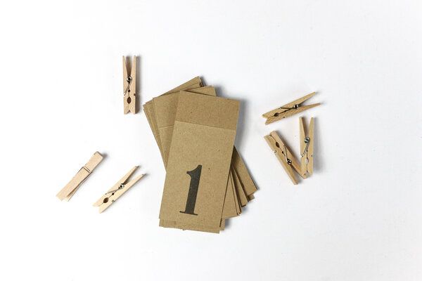 Adventskalenderzahlen-Anhänger aus Kraftpapier mit Holzklammern