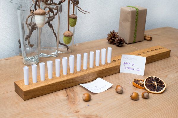 Gutschein-Adventskalender aus Nussbaumholz mit eingerollten Botschaften